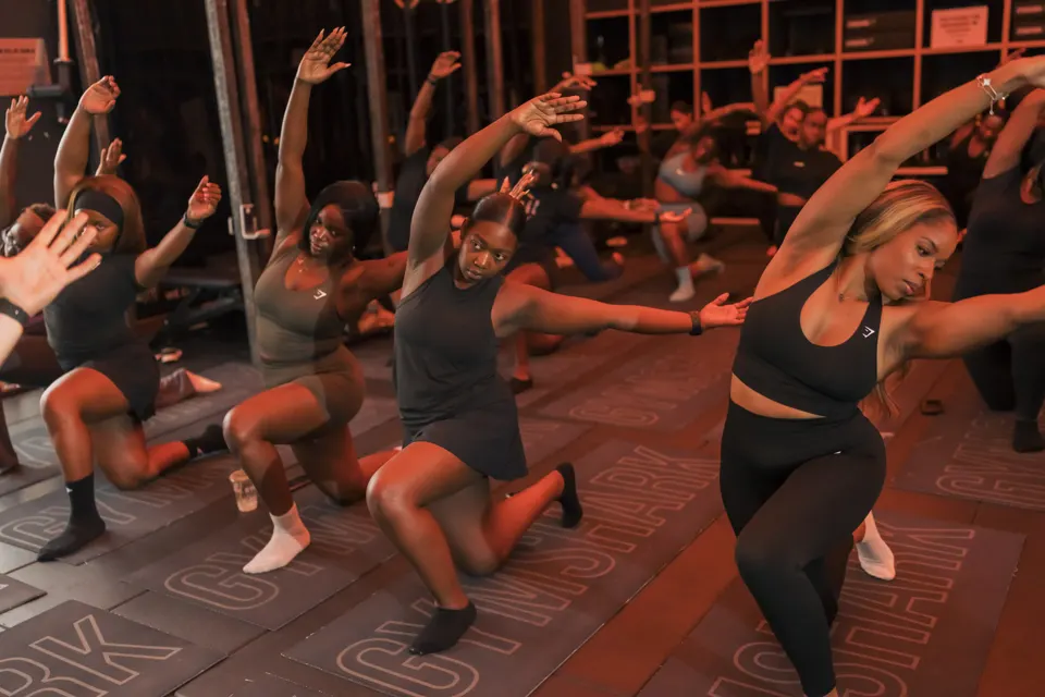 Members in a deep side stretch at our candlelit Gymshark studio class