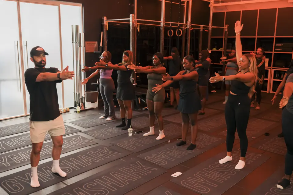 An instructor leading the warm-up at our Gymshark studio class, Gymshark mats underfoot