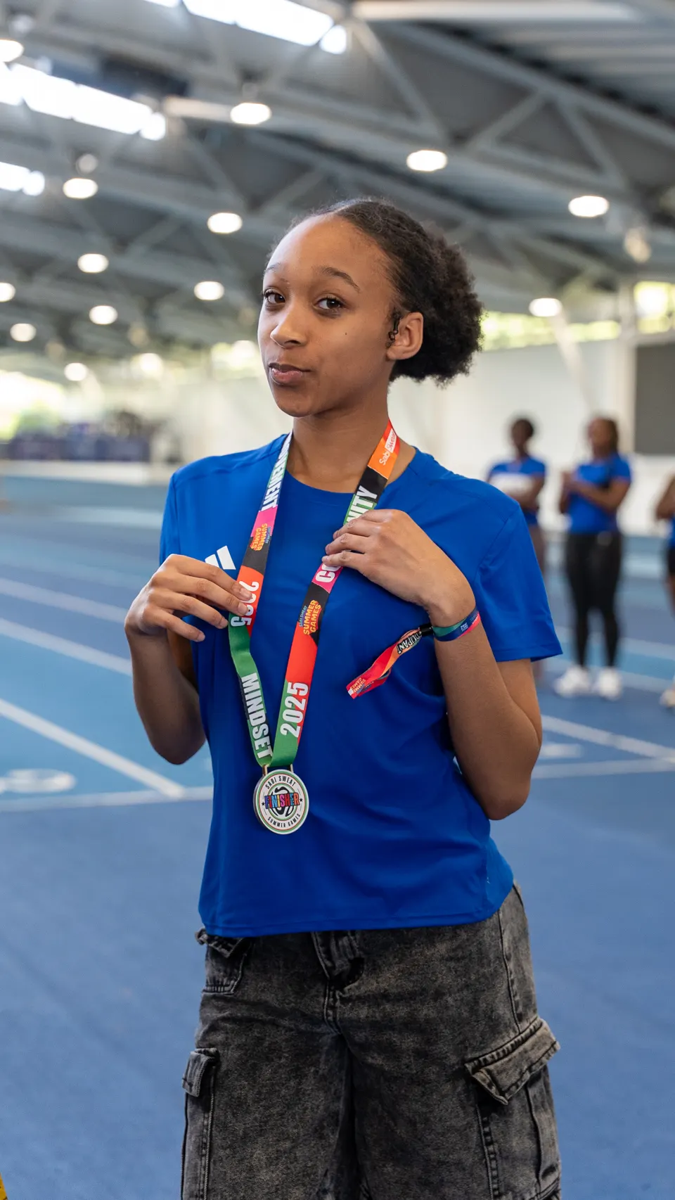 A young member wearing her finisher medal with quiet pride on the track