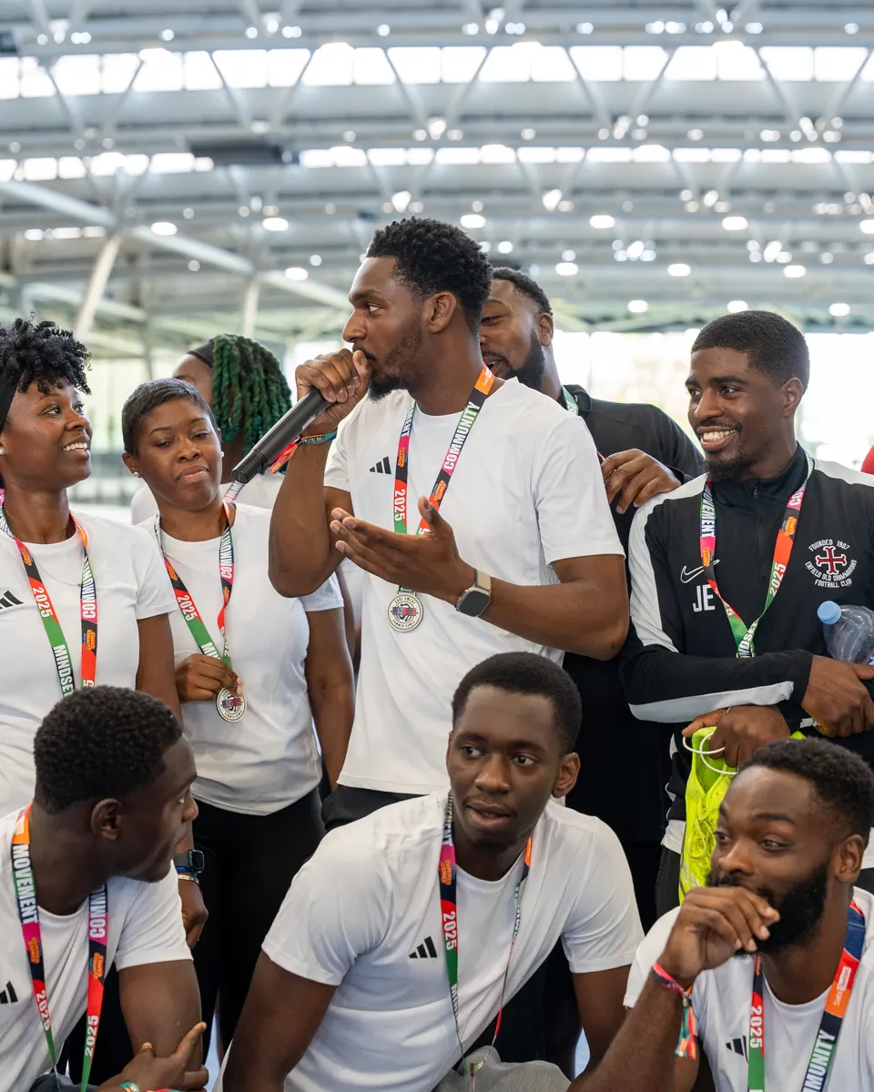 Members with medals around their necks laughing together after the Summer Games
