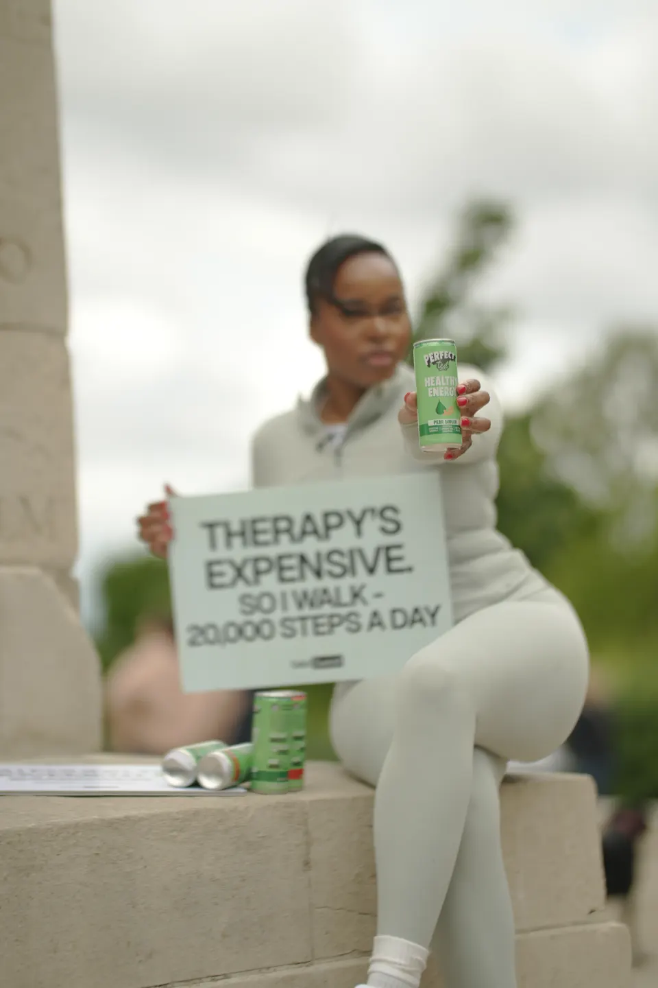 A member holding the Therapy's Expensive sign at a Move Together walk