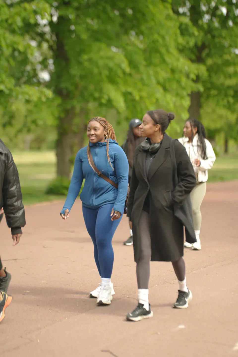 Members walking together down a tree-lined park avenue