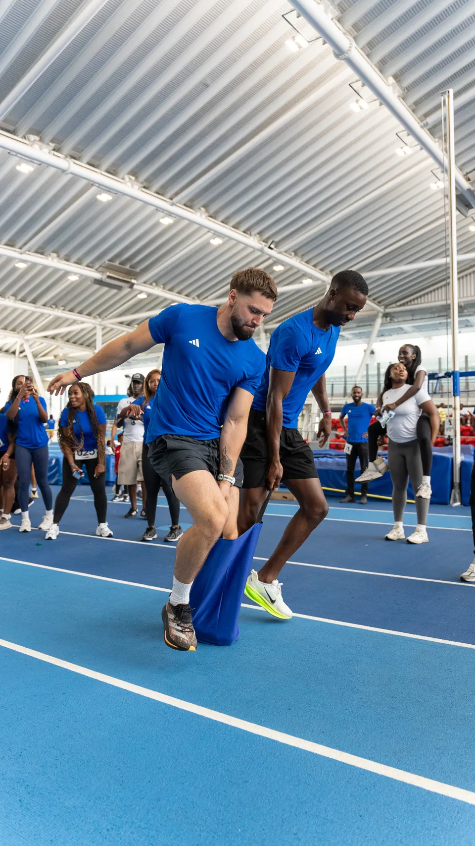 A member mid-leap in the sack race, crowd behind him