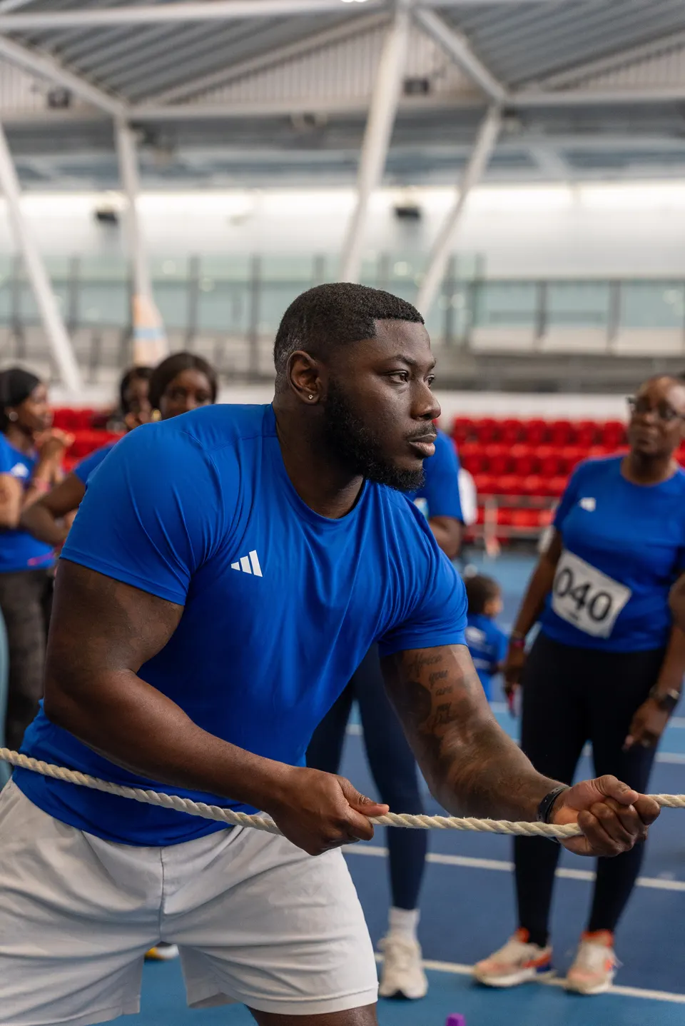 Rotating photos of the community: men and women in a Summer Games tug of war, children with their medals, the Lagos Shakeout Run, the Gymshark studio class and a Move Together walk